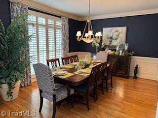 105 Finborough Ct, Kernersville, NC 27284 - dining area featuring wainscoting, a decorative wall, wood finished floors, and a chandelier