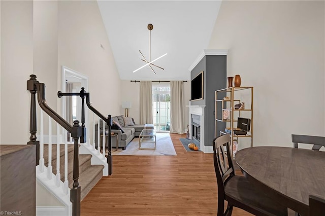 interior space featuring light wood-type flooring, high vaulted ceiling, and an inviting chandelier