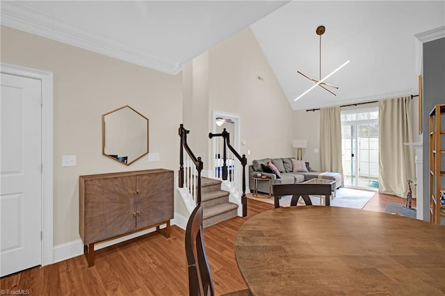 interior space with crown molding, high vaulted ceiling, a chandelier, and light wood-type flooring