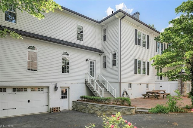 3054 Country Club Rd, Winston-Salem, NC 27104 - back of property with a garage, a chimney, and driveway