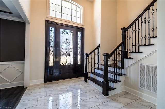 entrance foyer with a high ceiling, marble finish floor, visible vents, and baseboards