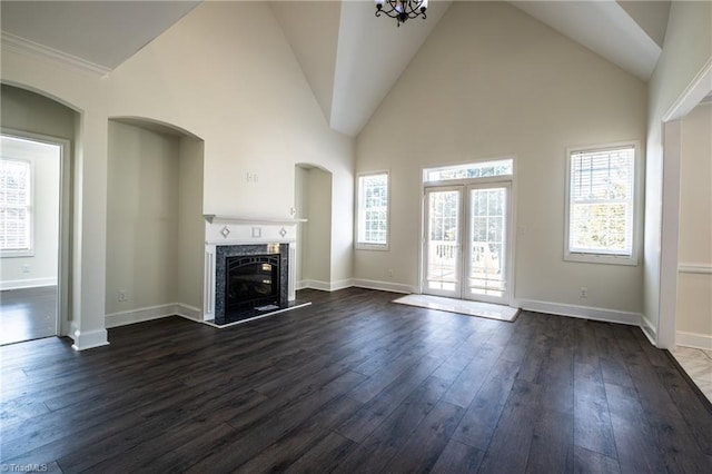 unfurnished living room featuring baseboards, high vaulted ceiling, dark wood-style flooring, and a high end fireplace