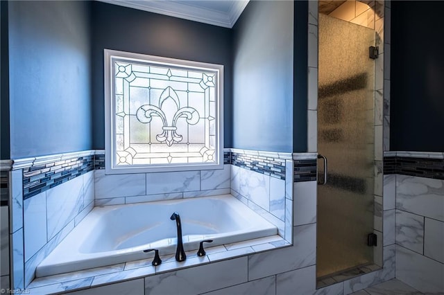 bathroom with a stall shower, ornamental molding, and a garden tub