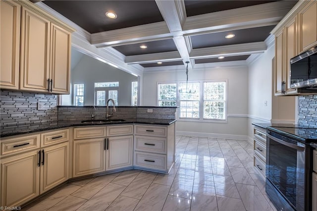 kitchen featuring cream cabinetry, beamed ceiling, a sink, and appliances with stainless steel finishes