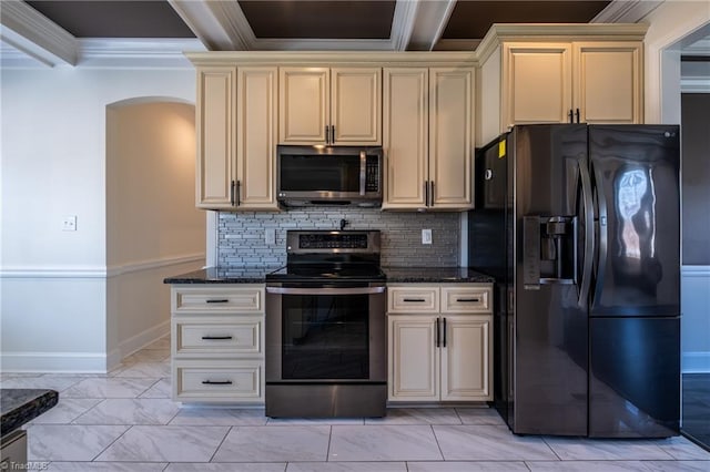 kitchen featuring marble finish floor, stainless steel appliances, cream cabinets, and dark stone countertops