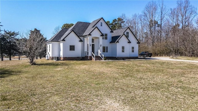 view of front of property with board and batten siding, a front yard, and a shingled roof