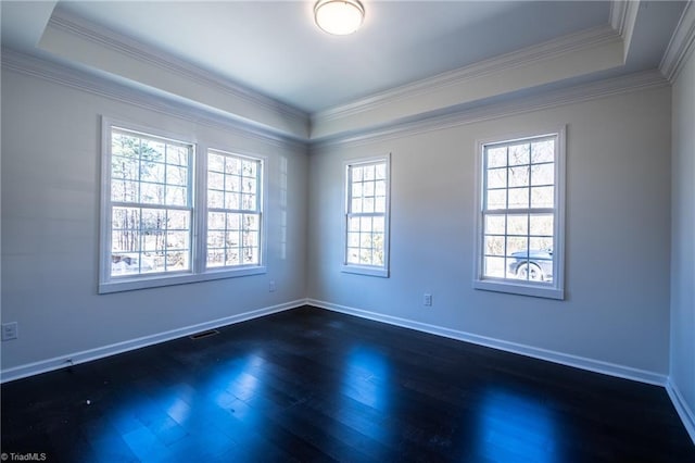 unfurnished room with dark wood-type flooring, visible vents, baseboards, ornamental molding, and a raised ceiling