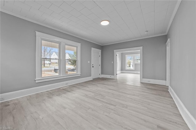 empty room featuring ornamental molding and light wood-type flooring