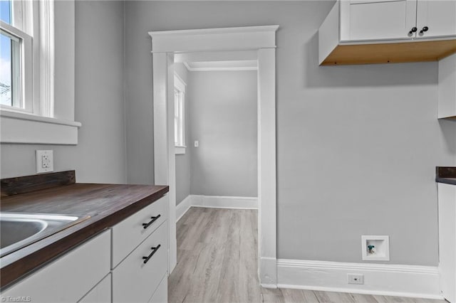 kitchen featuring wood counters, light hardwood / wood-style floors, and white cabinets