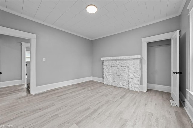 unfurnished bedroom with ornamental molding, light hardwood / wood-style floors, and a closet