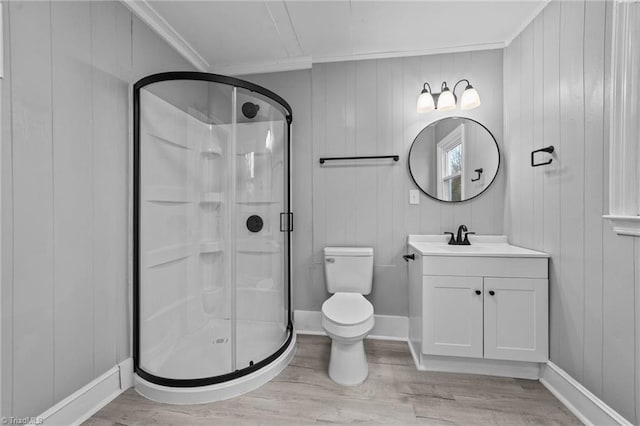 bathroom with hardwood / wood-style floors, vanity, ornamental molding, toilet, and a shower with door