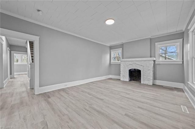 unfurnished living room featuring crown molding, plenty of natural light, and light hardwood / wood-style flooring