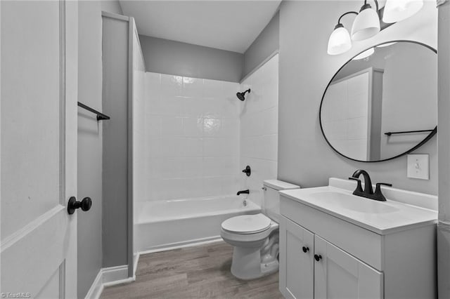 full bathroom with hardwood / wood-style flooring, an inviting chandelier, vanity, tiled shower / bath, and toilet