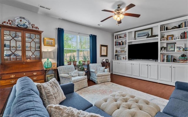 living room with ceiling fan, wood finished floors, and visible vents