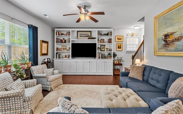 living room featuring visible vents, a ceiling fan, stairs, and dark wood-type flooring