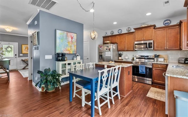 kitchen with appliances with stainless steel finishes, dark wood-style flooring, visible vents, and brown cabinetry