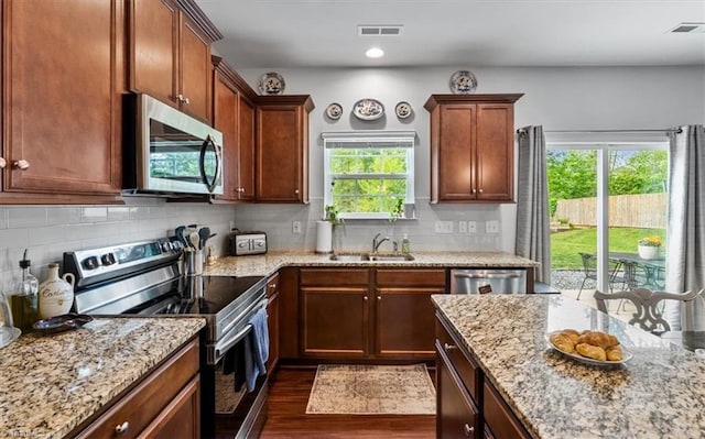 kitchen featuring a sink, visible vents, appliances with stainless steel finishes, and dark wood finished floors