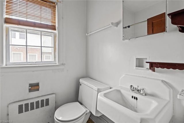 bathroom with a sink, toilet, and radiator heating unit