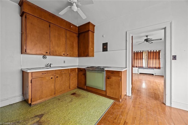 kitchen with gas stove, ceiling fan, radiator heating unit, and light countertops