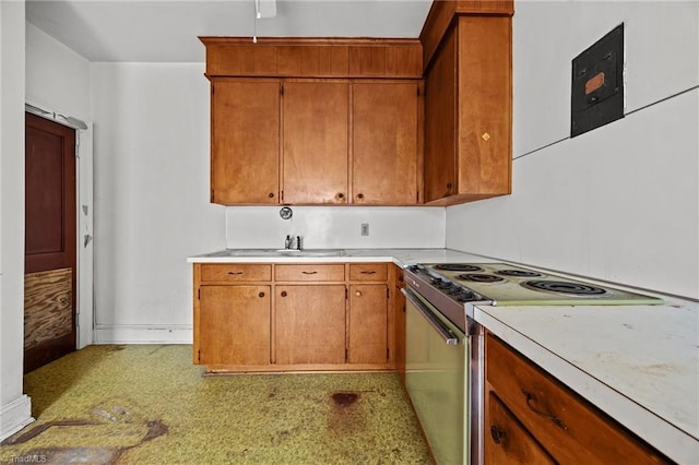 kitchen with light countertops, brown cabinetry, electric stove, and light floors