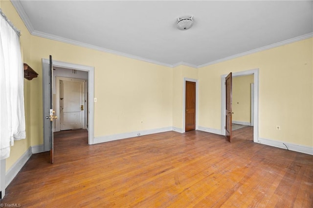 empty room with light wood-style flooring, crown molding, and baseboards