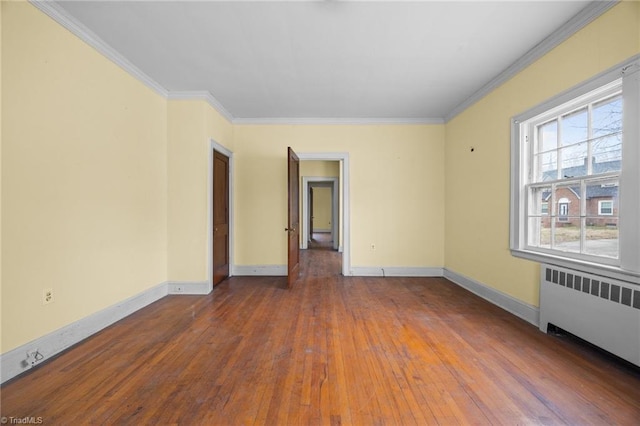 empty room featuring radiator, baseboards, and ornamental molding