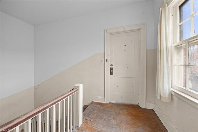 corridor featuring a wealth of natural light and an upstairs landing