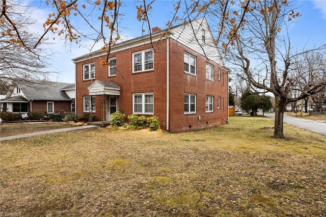 colonial home with a front yard, brick siding, and crawl space