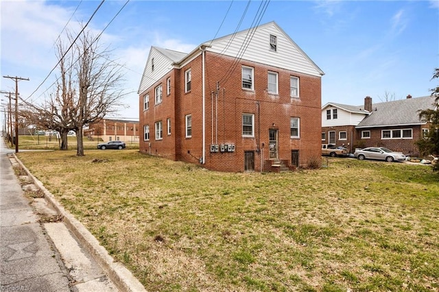 view of property exterior with a lawn and brick siding