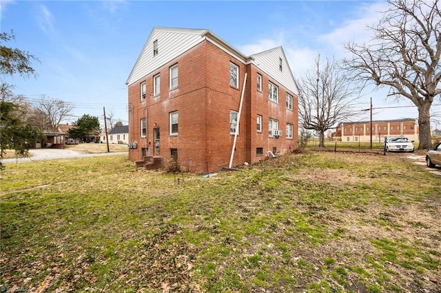 view of side of property featuring a yard and brick siding