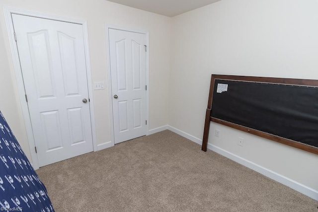 unfurnished bedroom with carpet floors and baseboards