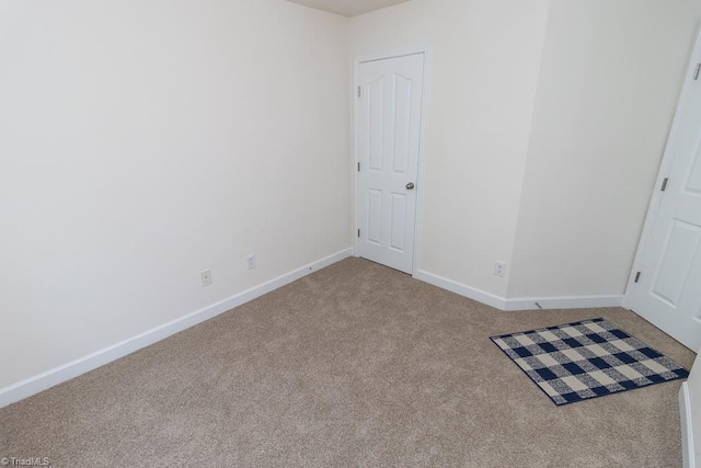 unfurnished room with carpet and baseboards