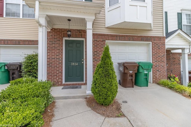 entrance to property featuring brick siding and a garage