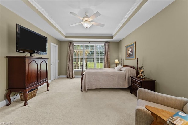 bedroom with crown molding, light colored carpet, ceiling fan, and a tray ceiling