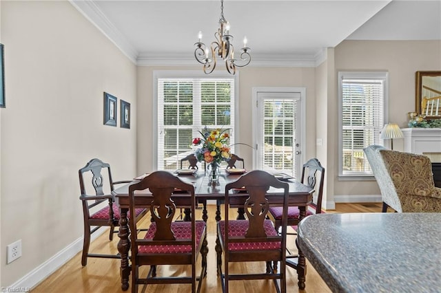 dining area with crown molding, a chandelier, and light hardwood / wood-style flooring