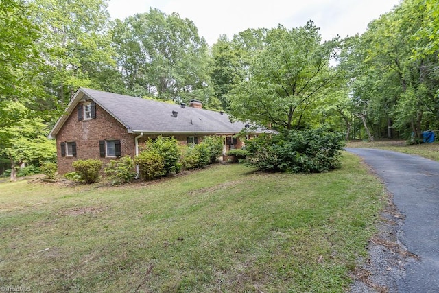 4984 US Highway 220, Asheboro, NC 27205 - view of home's exterior featuring a chimney, brick siding, a lawn, and asphalt driveway
