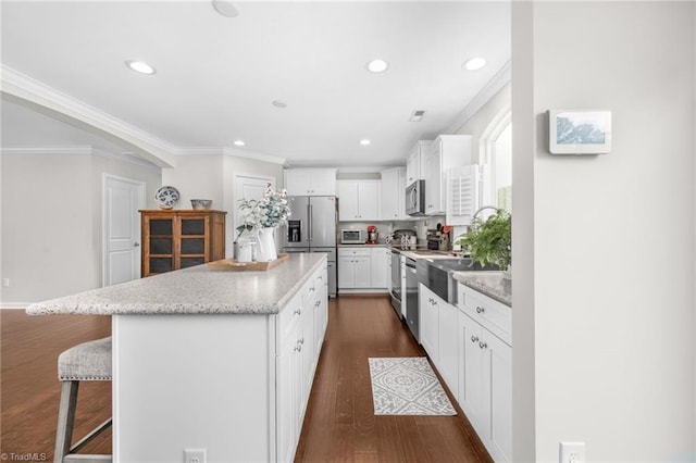 742 Teague Rd, Winston-Salem, NC 27107 - kitchen with stainless steel appliances, a kitchen island, a kitchen bar, recessed lighting, and ornamental molding