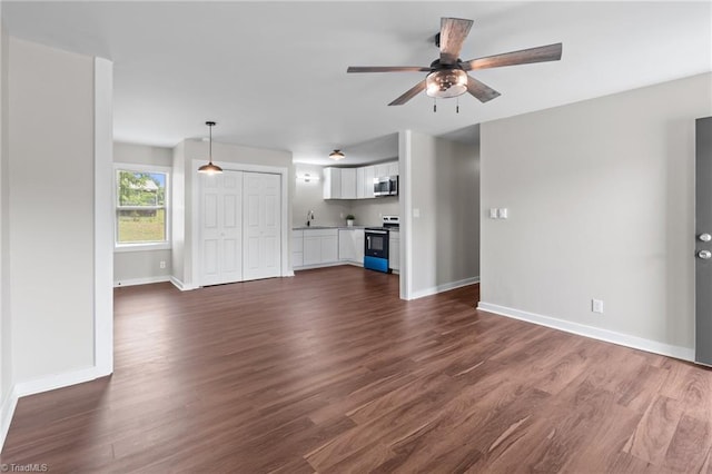 unfurnished living room with a sink, a ceiling fan, and dark wood finished floors