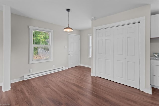 foyer with baseboard heating, dark wood-style flooring, and baseboards