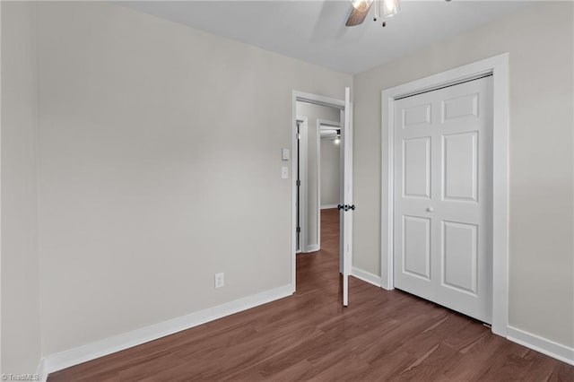 unfurnished bedroom with wood finished floors, baseboards, a ceiling fan, and a closet