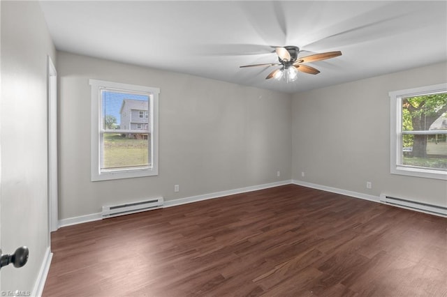 spare room featuring baseboard heating, dark wood-type flooring, a ceiling fan, and baseboards