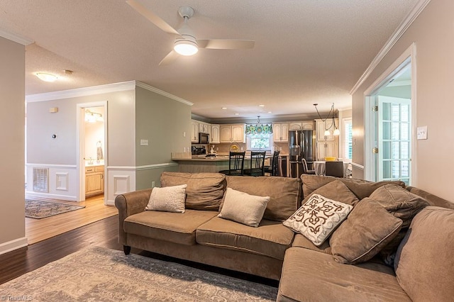 97 Shadylawn Dr, Winston-Salem, NC 27104 - living area with crown molding, ceiling fan, wood finished floors, wainscoting, and a textured ceiling