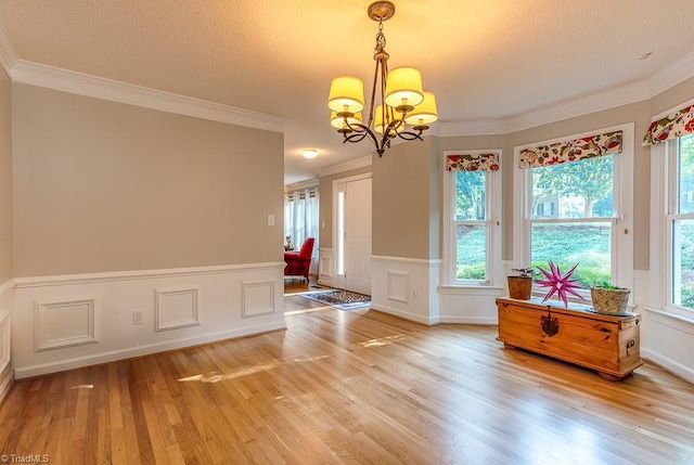 97 Shadylawn Dr, Winston-Salem, NC 27104 - dining area featuring a chandelier, light wood-style floors, wainscoting, crown molding, and a decorative wall