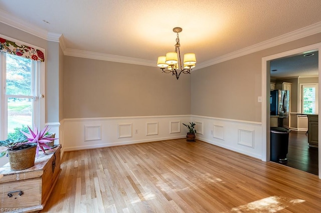 97 Shadylawn Dr, Winston-Salem, NC 27104 - spare room featuring ornamental molding, light wood finished floors, a chandelier, and a wainscoted wall