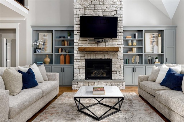 living room featuring a stone fireplace, high vaulted ceiling, and hardwood / wood-style flooring