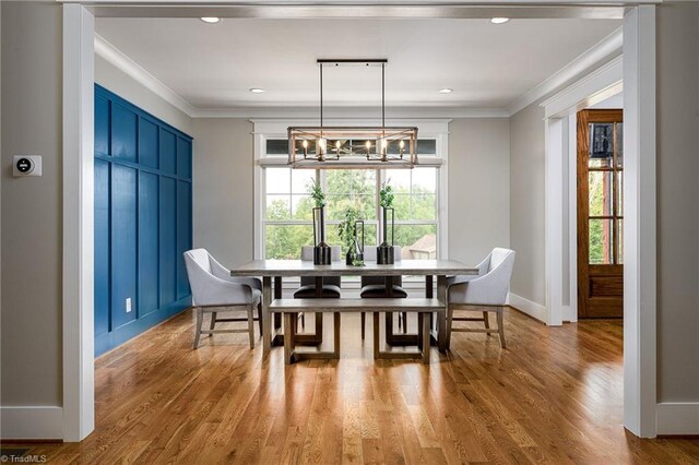 dining room with light wood-type flooring and crown molding