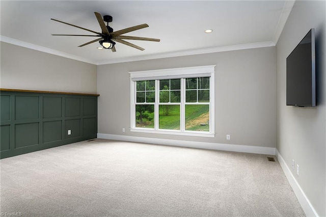 unfurnished room with crown molding, light colored carpet, and ceiling fan