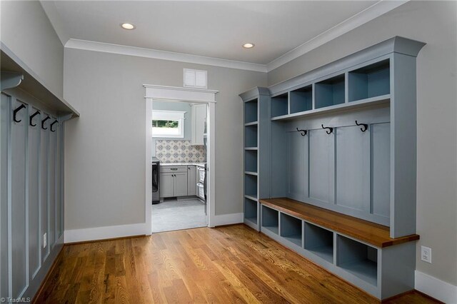 mudroom featuring ornamental molding and light wood-type flooring