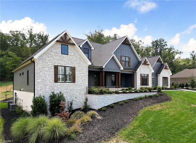 view of front of property featuring covered porch, a front lawn, and board and batten siding