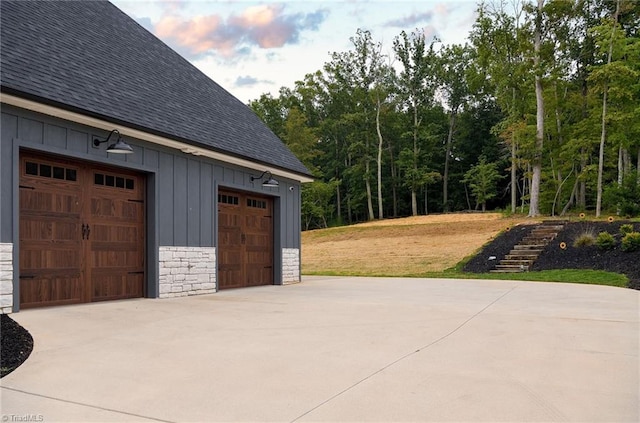 garage at dusk featuring wood walls